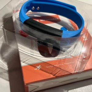 Blå smartklocka med svart display - Säljer en helt ny och oanvänd blå smartklocka med svart display och silikonarmband. Klockan har funktioner för hälsospårning och aktivitet, perfekt för dig som vill hålla koll på steg och puls. Enkel att använda och passar till träning.