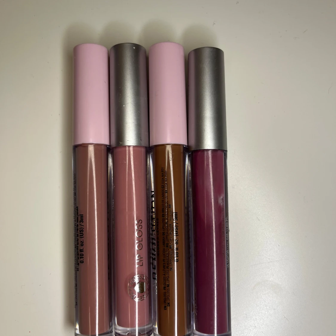 Fyra läppglans i olika nyanser