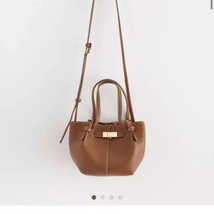Brun axelväska från Lindex - Virala Lindex väskan! Supersnygg🙌🏼💗. Väskan har en justerbar axelrem och ett dekorativt spänne framtill. Slutsåld online och de flesta butiker därav priset!!
