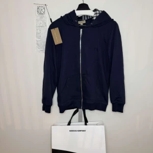 Mörkblå Burberry hoodie - Mörkblå Burberry hoodie i storlek medium Köpt i 2023 så snart två år sen kvitto,  taggen och såklart hoodien fås med vid köp om jag själv hade fått säga hade jag sagt att den passar mer som en small än en medium alltså lite mindre i storleken pris går att förhandla men skicka inga skambud, sparsamt använd!