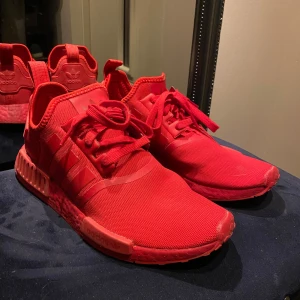 Röda Adidas NMD sneakers - Ett par sparsammt använda NMDs, orginal pris låg runt 1000kr, men säljes nu för 399kr:) 