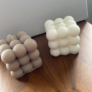 Två kubformade ljus i beige och vitt - Unika kubformade ljus med bubblig design. Ett ljus är i en mjuk beige nyans och det andra i klassiskt vitt. Perfekta som dekorativa detaljer i hemmet eller som en fin present. 50kr/styck eller båda för 80