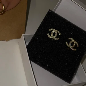 Guldfärgad örhänge med stenar - Helt oanvänd, köpt utomlands. Materialet är jag inte säker på.   • Låda medföljer ej, dock paketeras smyckena säkert för leverans