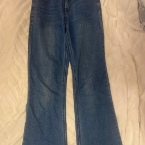 Blå jeans från UNIQ - Säljer ett par blå bootcut jeans från UNIQ och är tillverkade i denim. Perfekta för en avslappnad stil.