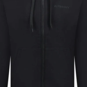 Svart hoodie från Burberry - Snygg svart hoodie från Burberry med dragkedja och justerbar huva. Perfekt för en stilren och avslappnad look. Diskret Burberry-logga på bröstet.