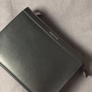 Valentino Herr Clutch - Valentino Herr Clutch i mattsvart som passar suveränt till lite finare tillfällen. Köpt på Zalando för cirka en månad sedan och kommit till användning vid ungefär tre användningsområden denna månad. 