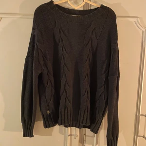 Svart stickad tröja med flätmönster - Mysig svart stickad tröja med ett snyggt flätmönster framtill. Använd fåtal gånger 