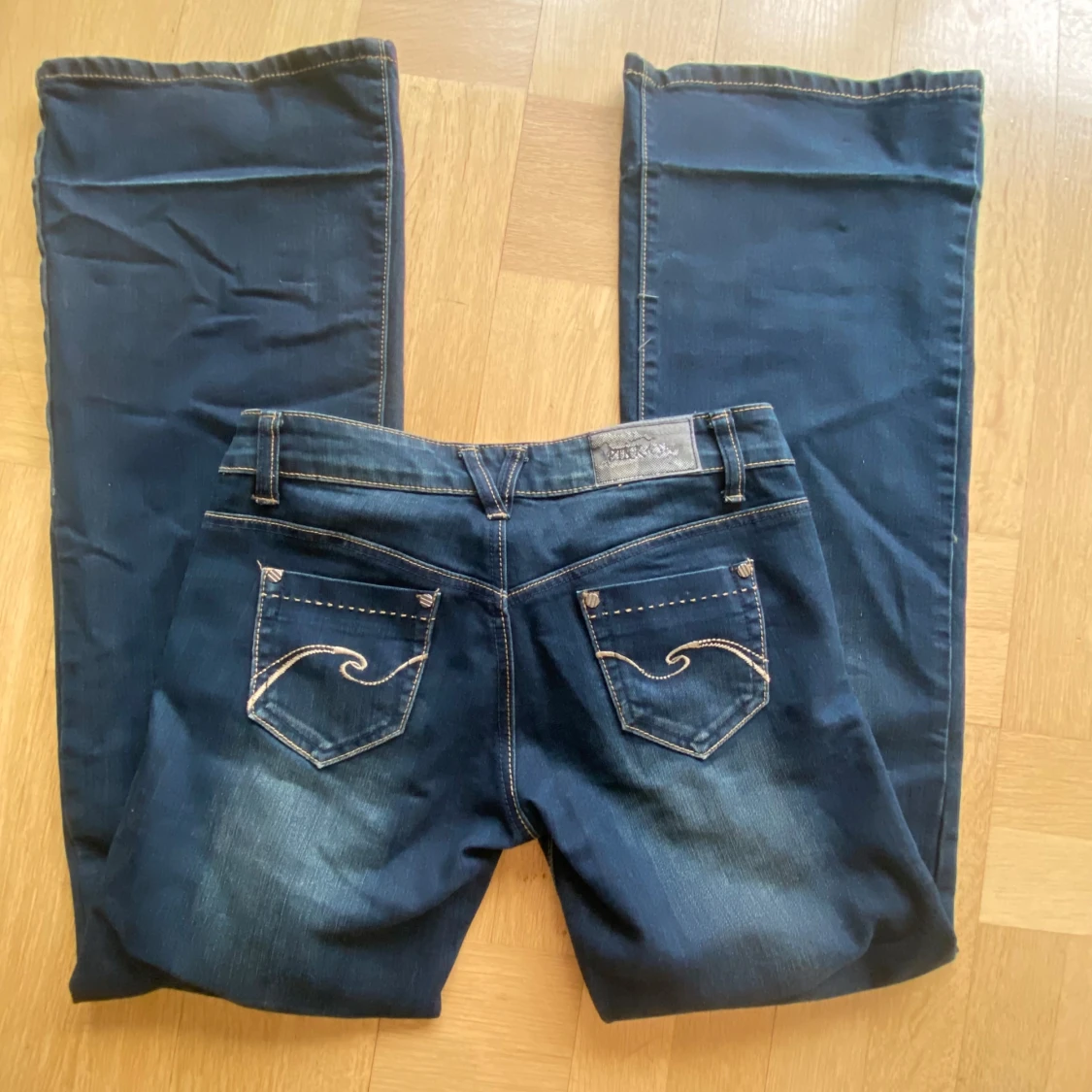 Mörkblå jeans med broderade bakfickor