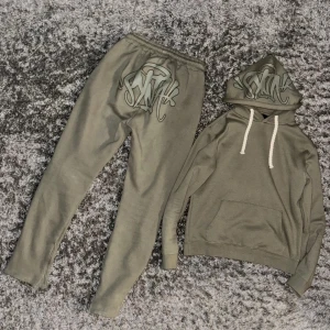 Sällsynt ”synaworld” tracksuit i färgen sage green - Tracksuiten har används väldigt få ggr pga för liten. Tröjan är i strl L (passar M) Byxorna är i strl XL (passar L/M). Skicket på tracksuiten är 8/10✅. Kvitto finns emot begäran. Nypris 3200kr inklusive frakt ifrån england. Pris kan diskuteras.💯🔥