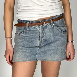 Jeanskjol i ljusblå denim - Trendig kort jeanskjol i ljusblå denim med klassisk femficksdesign. Perfekt för en avslappnad stil. Kjolen har en normal passform och är lätt att matcha med olika toppar. Superbra skicka 💞