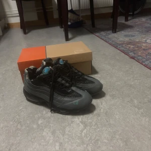 Nike cortez 95 air max  - Snygga Nike sneakers i svart och grått med coola camouflage-detaljer på insidan. Skorna har snörning och en sportig design med en blå logga på plösen. Perfekta för en casual look. Använda några gånger 