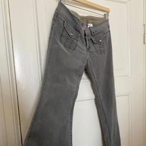 Grå bootcut jeans från Gap Pluggy - Garderobsrensning pågår! 👗 Shoppa loss bland en massa fina plagg. Kika in på min sida, så kanske du hittar något mer du gillar!   Har du frågor om ett plagg? Tveka inte att höra av dig! (OBS: Kan tyvärr inte ta bilder med plaggen på.).     Säljer ett par gråa bootcut jeans från Gap Pluggy med två stora fickor framtill med lock och knappar. Jeansen har