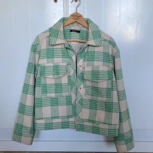Grön och vit rutig skjortjacka från Gina Tricot - Skjortjacka i grönt och vitt rutigt mönster från Gina Tricot. Jackan har krage, knappar framtill och två fickor. 