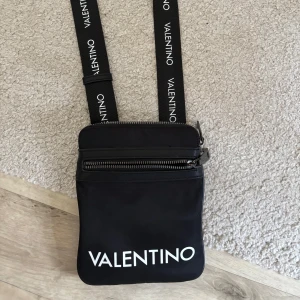 Valentino Axelväska - Säljer en snygg svart axelväska från Valentino. Finns många fickor i väskan och perfekt för om man ska ut. Pris går att diskutera