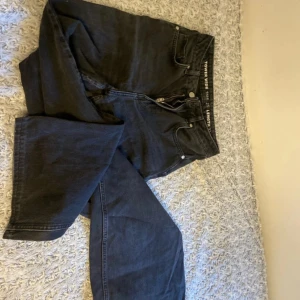 Svarta bootcut jeans från Topshop - Säljer ett par svarta jeans från BikBok med bootcut-modell. Jeansen har klassisk femficksdesign, dragkedja och knapp framtill samt bälteshällor. Perfekta för dig som gillar en tidlös och stilren look.