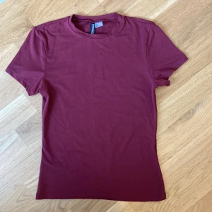 Vinröd topp - Säljer en vinröd figursydd topp som knappt är använd. Hör av dig för frågor eller fler bilder!