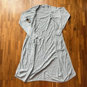 Lång cardigan - Lång grå cardigan med fickor, går ner under knäna på mig som är 172 cm, fint skick, storlek M