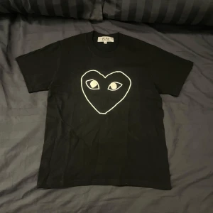 Svart t-shirt från Comme des Garçons Play med hjärta - En riktig snygg T-shirt från Comme des Garçons. | Den passar som en vanlig T-shirt. Den passar mig som är 170cm och den passar om man är där omkring i längden. | Det är bara att höra av sig om man har några frågor eller vill ha flera bilder🌄🌄🌄