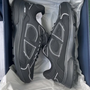 Dior B30 - Säljer ett par svarta Dior sneakers med vita detaljer och tydlig Dior-logga. Priset kan diskuteras ‼️Perfekta för dig som gillar exklusiva och trendiga sneakers.