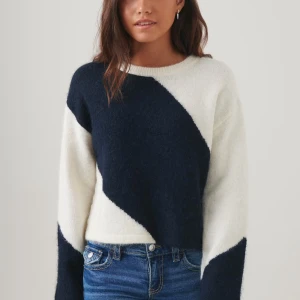 Svart och vit stickad tröja - Snygg stickad tröja i blå och vitt med ett diagonalt mönster. Tröjan har långa ärmar, perfekt för en trendig look. Den är mjuk och bekväm, idealisk för kyligare dagar. Storlek 158-164 men passar även xxxs-s💘 Mycket bra skick förutom en omärkbar fläck på ärm (skickar bild privat)