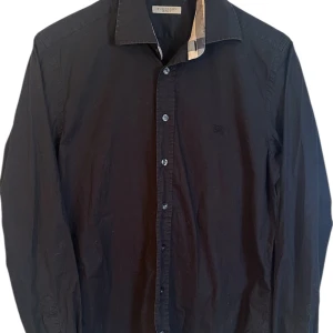 Burberry skjorta  - Burberry skjorta svart. Storlek M. Skick 9/10 fin! Pris 990kr finns att köpa på våran hemsida Fashionels.com