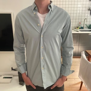 Ljusblå skjorta från Morris  - Säljer en stilren ljusblå skjorta från Morris Stockholm i storlek S. Skjortan har klassisk krage, knappar framtill och diskret broderad logga på bröstet. Perfekt för en clean och snygg look.