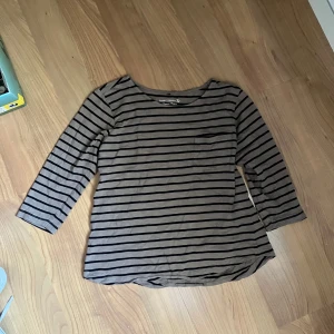 randig tröja - brun- och svartrandig tröja med trekvartsärm.