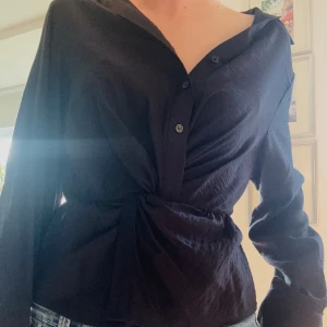 Twist knut skjorta  - Säljer svart skjorta med en twistad knut framtill och slit i armarna💗från Gina, linnematerial, säljer då de är fel storlek för mig 💖skriv vid frågor 