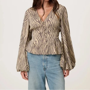 Zebramönstrad blus med ballongärm - Helt ny Adoore blus som aldrig är använd, köpte två då jag var osäker på storlek i 34. Passar någon som vanligtvis är 32 - 36