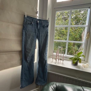 Ljusblå bootcut jeans - Snygga ljusblå jeans med bootcut passform och klassisk femficksdesign. Jeansen har låg midja och är tillverkade i mjukt denimtyg som ger en avslappnad vibe. Perfekta för dig som gillar en retroinspirerad look med lite utsvängda ben.