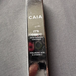 CAIA It's Iconic Concealer 3C - CAIA It's Iconic Concealer i nyansen 3C, en satin radiance concealer med hyaluronsyra och vitamin C. Kommer i en snygg silvrig förpackning och ger en naturlig finish. Perfekt för att täcka mörka ringar och ojämnheter.Helt nytt oöppnat 
