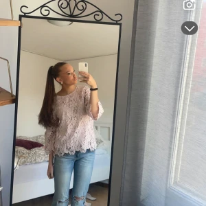 Ljusrosa spetsblus med trekvartsärm - Säljer en ljusrosa blus i spets med fina blommiga detaljer och trekvartsärm. Blusen har en rund halsringning och är något loose i passformen. Perfekt för dig som gillar romantisk stil och vill ha något extra till garderoben.