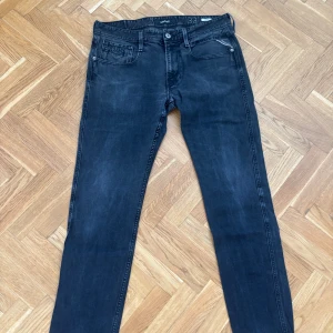 Replay svarta slim jeans herr - Snygga svarta jeans från Replay i modellen Anbass. Jeansen har en slim passform, klassisk femficksdesign och diskreta slitningar för en cool look. Tillverkade i stretchig bomullsdenim som sitter skönt hela dagen.