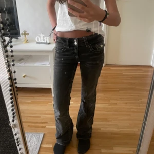 Svarta bootcut jeans med låg midja - Säljer ett par mörk gråa jeans med snygg bootcut och låg midja. Köpta på Gina Tricot i storlek 152, men passar även storlek XXS eller XS. 