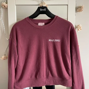 Vinröd sweatshirt från Pull&Bear XS - Vintage Vinröd sweatshirt från Pull&Bear Pacific Girls Collection i storlek XS. Tröjan har rund halsringning, trycket 'MALIBU' på bröstet och långa ärmar. Mjuk insida och klassisk passform, perfekt för en chill look.som medium går passar också