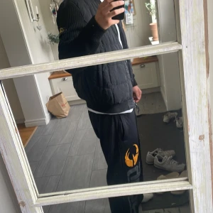 Svart pufferjacka från Stone Island - Säljer en svart pufferjacka från Stone Island med ikonisk patch på ärmen. Jackan har quiltad kropp, ribbade ärmar och dragkedja framtill. Materialet är en mix av nylon och polyester med Primaloft-foder för extra värme. Perfekt för dig som vill ha en clean och stilren look. Storleken sitter ej som en xl sitter mer som en L/ stor M. Priset kan diskuteras.