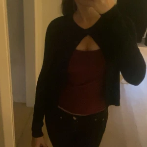 Svart cardigan  - Snygg svart croppad kofta med lång ärm. Perfekt att slänga över ett linne eller topp för en chill och stilren look. Passar dig som gillar minimalistiska plagg med en twist.