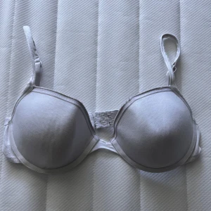 Vit bh från Esmara Lingerie - En enkel vit bh från Esmara Lingerie med vadderade kupor och justerbara axelband. Bh:n har klassisk form och stängs med hyskor bak. Vid frågor hör av dig!