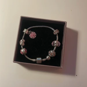 Silverfärgat berlockarmband med rosa detaljer - Jätte fint armband med berlocker!  Hör gärna av dig om du undrar något, köp gärna med Instabox då jag skickar snabbast där! Kvar tills markerad som såld 🫶🏼💘