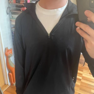 Träningströja  - Svart långärmad tröja från Newbody med half zip och hög krage, till för träning. Tröjan har hål för tummarna vid armarna, och är i tunn polyester, perfekt för träning. Aldrig använd. 