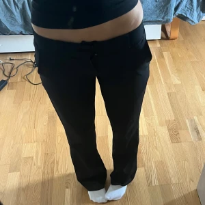 Svarta kostymbyxor från BikBok - Säljer ett par svarta kostymbyxor från BikBok i storlek 34. Byxorna sitter bra och har lite bootcut. Perfekta till en snygg topp eller skjorta för en clean look.