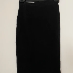 Svart knälång kjol från Gina Tricot XS - Svart knälång kjol från Gina Tricot, basically basics-kollektionen. Kjolen är rak i modellen och tillverkad av mjuk ekologisk bomull. Enkel och stilren design utan mönster eller detaljer, perfekt för dig som gillar minimalistiskt.