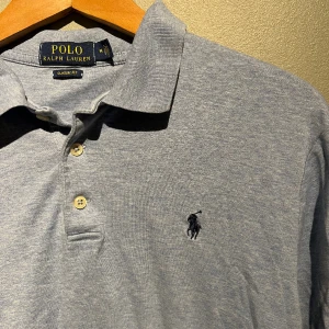 Ralph Lauren piké - Säljer en ljusblå/grå Ralph Lauren piké i storlek M men passar antagligen även S, den har inga särskilda tecken på användning då den är sparsamt använd! Säljer två andra pikéer i min profil om du vill kika in dem istället, fråga gärna vid funderingar!