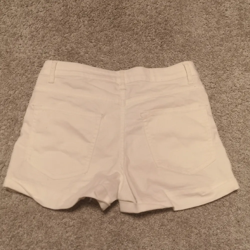 Ett par snygga högmidjade jeansshorts i en cremevit färg. Från divided i storlek 36. Shorts.