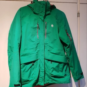 Ahkka jacka - Grön vattentät Ahkkajacka med rosa avtagbar fleecejacka på insidan. 