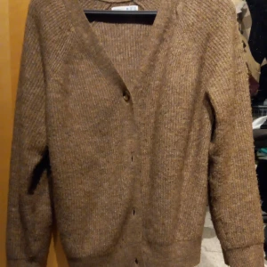 Stickad cardigan - En beige/brun stickad cardigan. Super fin o skön. Ny skick.