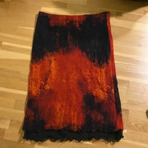 Svart och röd meshkjol - Säljer en urcool kjol i mesh. Mönstret varierar från svart till rött och har ibland nyanser av orange. 