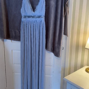 Balklänning  - Balklänning i fin ljusblå färg från asos i storlek 38. Passar bra i längden (är 165) kanske något lång utan klackar! Köptes för 4 år sedan och användes 1 gång på skolans bal! Klänningen är därmed i nyskick.