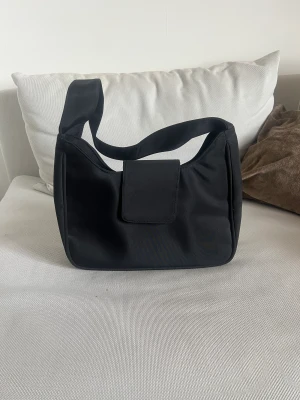Fendi inspirerad väska - Fendi inspirerad väska i nylon, köpt second hand och finns inget märke. Har själv aldrig använt den och den ser så gott som ny ut.