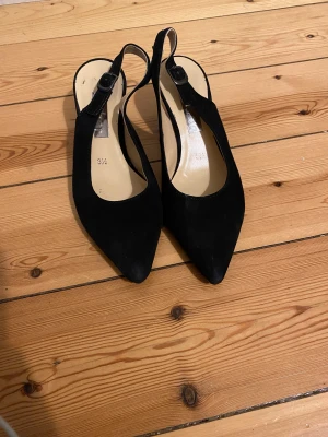 Svarta slingbacks strl 36 - Svarta slingbacks från Gabor storlek 36. Använd endast ett fåtal gånger, väl omhändertagna. Äkta mockaläder.